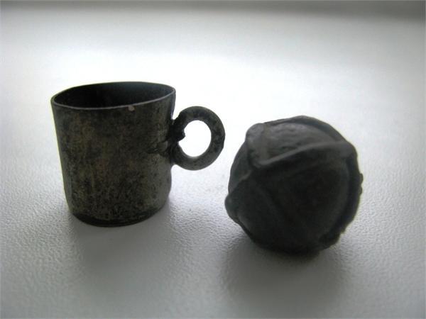 Пуля и мерная чашечка для пороха