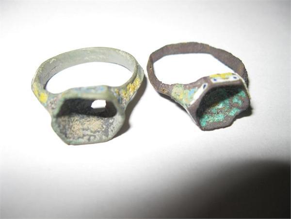 Перстень с шестиугольным щитком и остатками вставки синего стекла. Каст и внешняя сторона обруча украшены разноцветной эмалью (жёлтой, белой, голубой). На жёлтых и белых частях нанесены синие точки