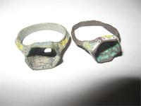 Перстень с шестиугольным щитком и остатками вставки синего стекла. Каст и внешняя сторона обруча украшены разноцветной эмалью (жёлтой, белой, голубой). На жёлтых и белых частях нанесены синие точки