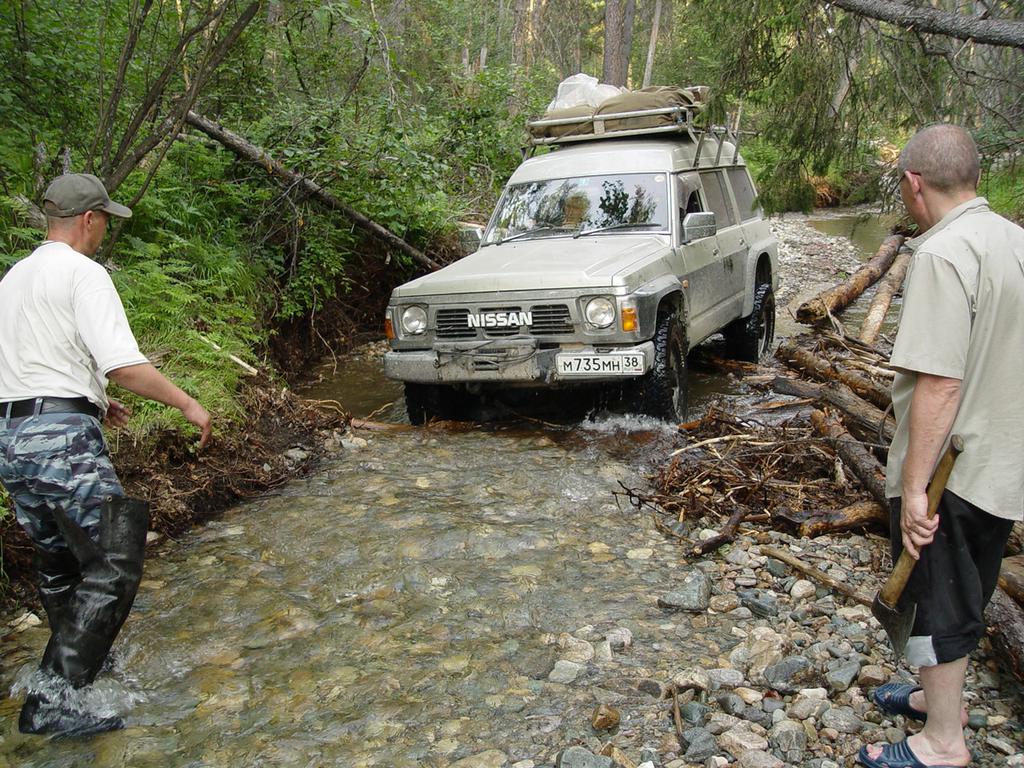 Джип медленно ползет прямо по извилистому галечному руслу ручья